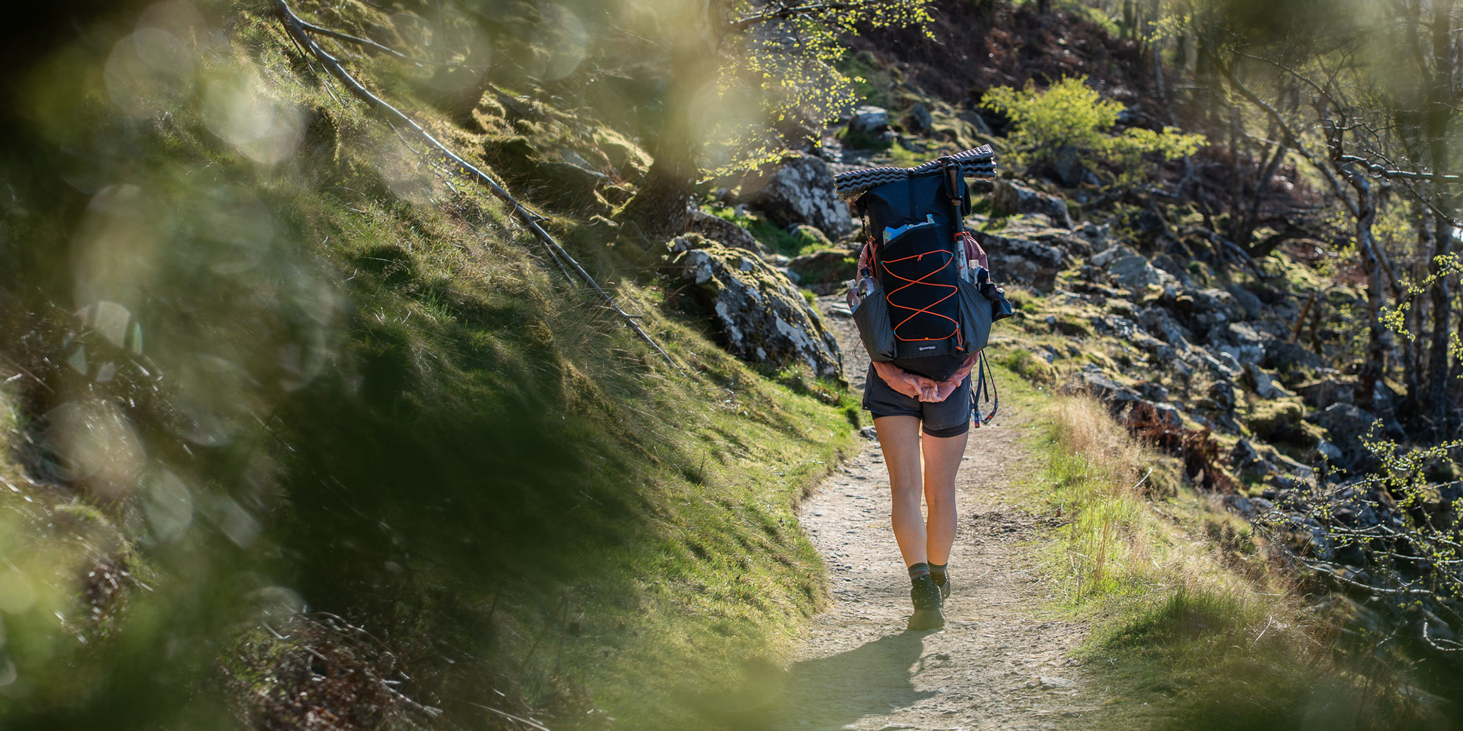 Person hiking on a trail with a backpack in a natural setting